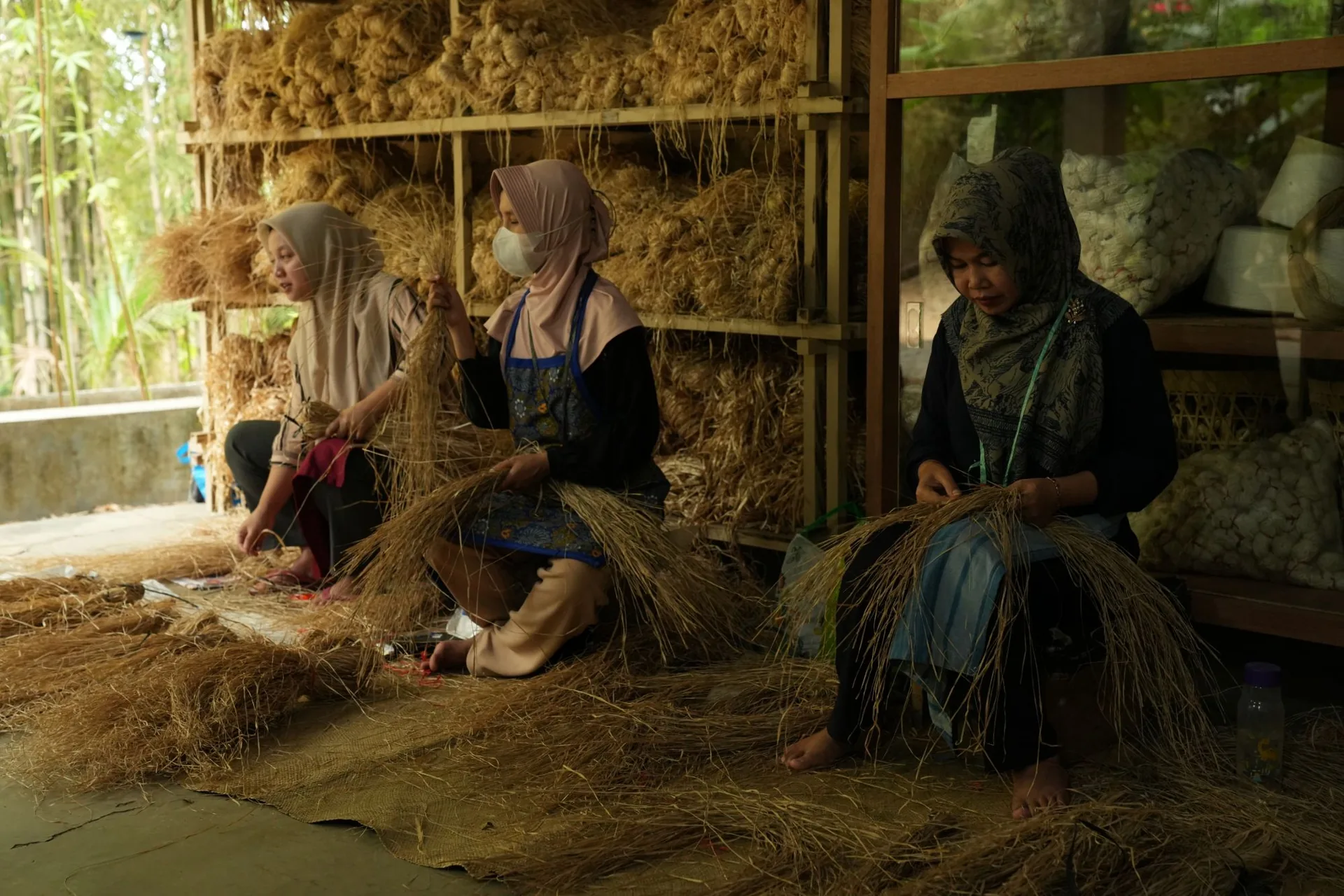 Three women sorting natural fibre by hand