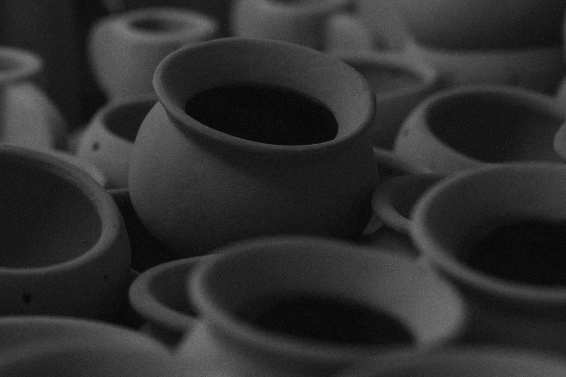 Unfired clay pots in a pottery workshop, in black and white