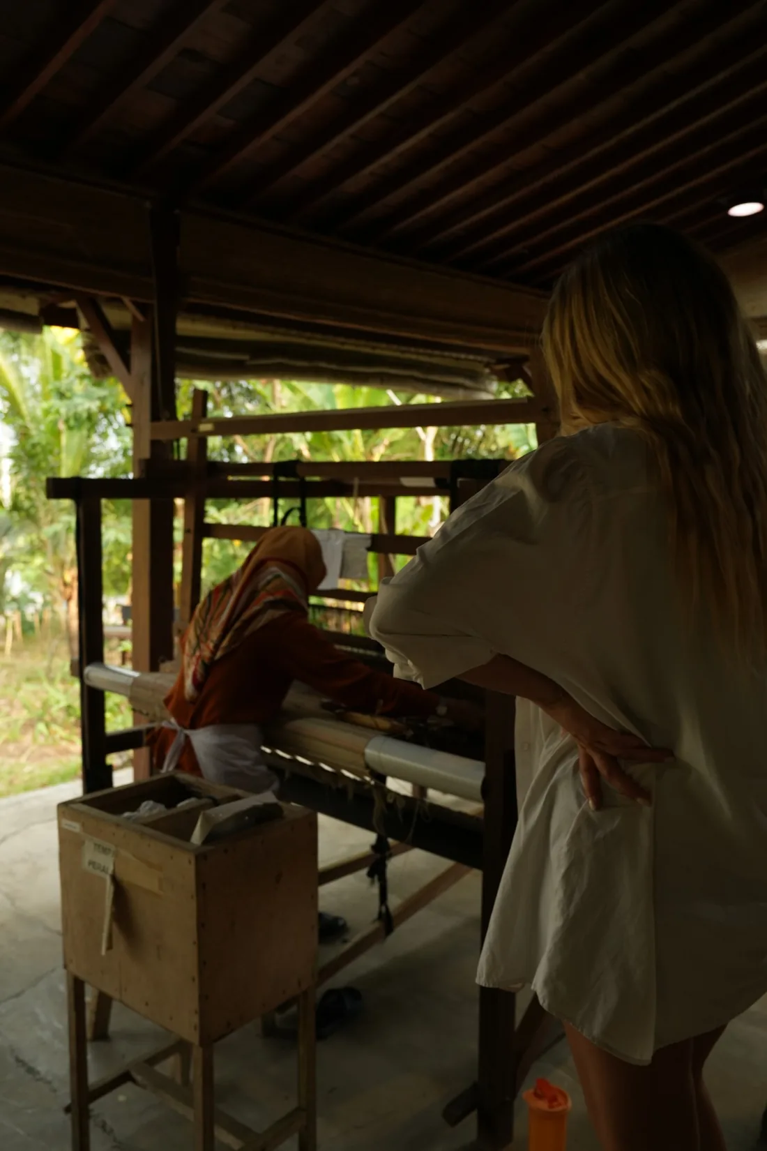 Laura Canu watching a weaver at a hand loom