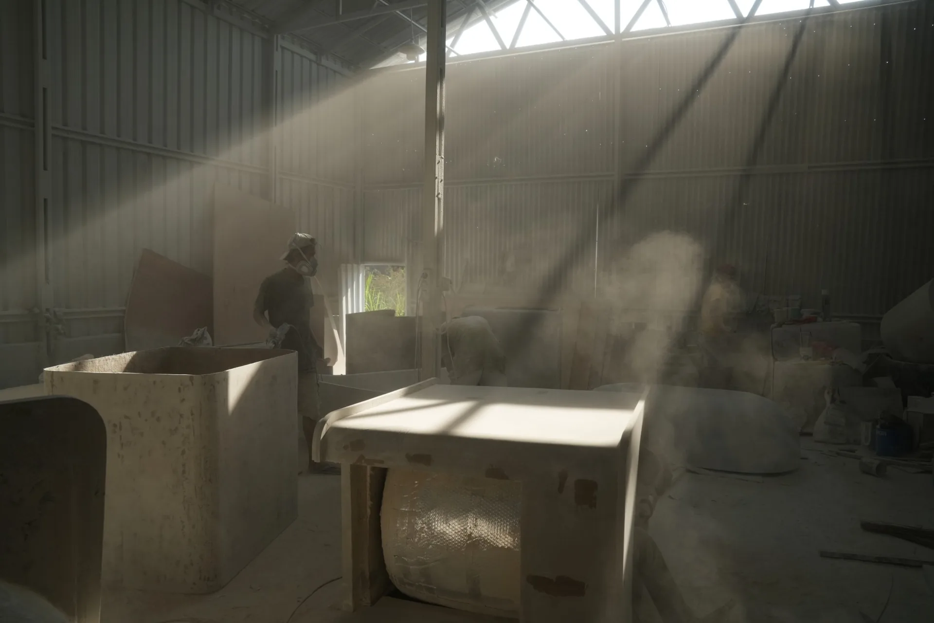 Makers finishing terrazzo pieces in a sunlit workshop